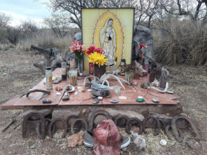 The communal altar, full of amulets, flowers and other offerings, at the No Más Muertes aid camp