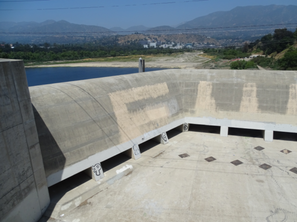 A view of the mountains, the reservoir, and the dam in the foreground.
