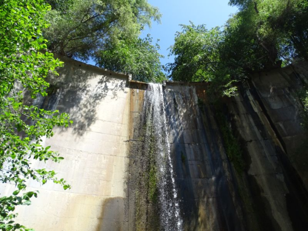 Water flows over the top of a dam.