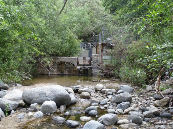 A check dam with boulders in the foreground.