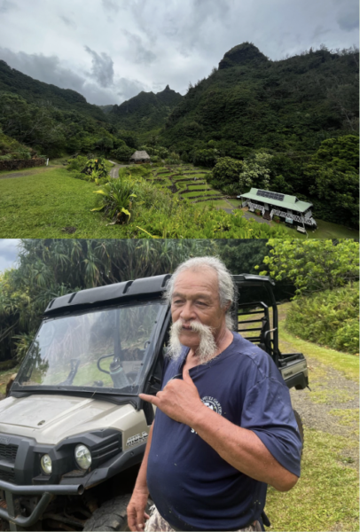 Uncle Moku standing in front of an ATV, which he manages the land at Limahuli Gardens  in Kauai, which is green and lush in the valley of the mountains. He has a big white moustache  and is holding is hand in a “Shaka”with the thumb and pinky finger out 