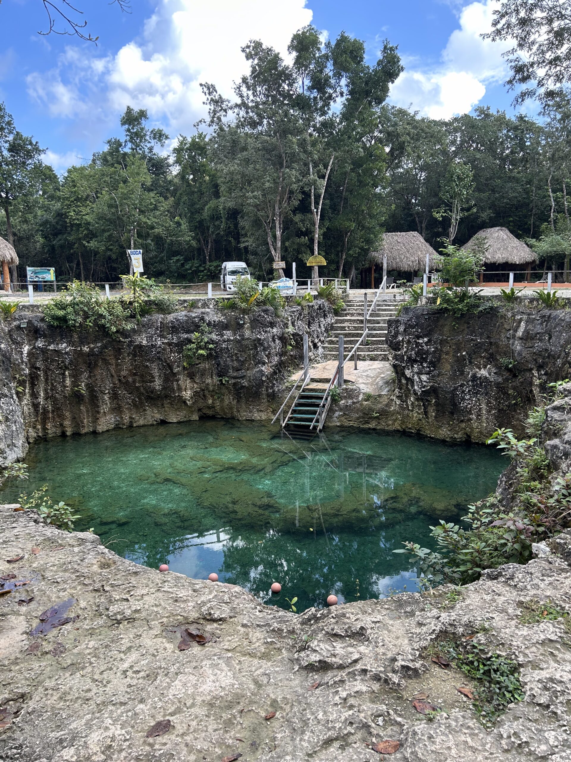natural open sinkhole filled with clear water in a sunny day;